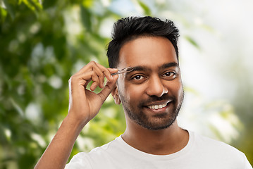 Image showing indian man with tweezers tweezing eyebrow hair