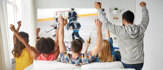 Image showing friends watching ice hockey on projector screen