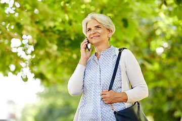 Image showing senior woman calling on smartphone in summer park