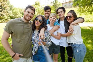 Image showing friends taking picture by selfie stick at summer