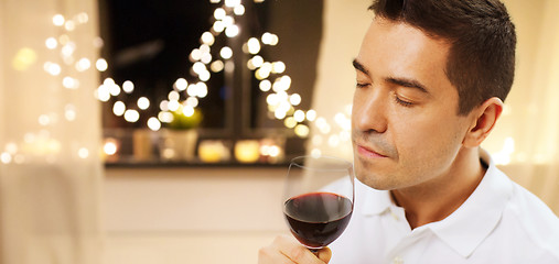 Image showing happy man drinking red wine at home on christmas