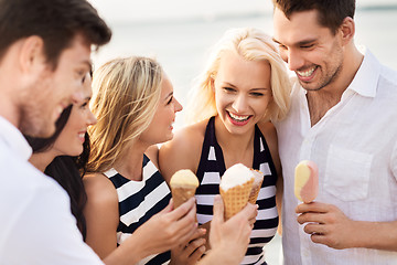 Image showing happy friends in striped clothes eating ice cream