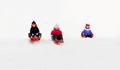 Image showing kids sliding on sleds down snow hill in winter