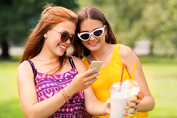 Image showing teenage girls with smartphone and shakes in park