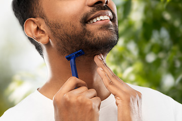 Image showing close up of man shaving beard with razor blade