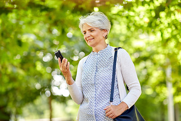 Image showing happy senior woman with smartphone at summer park