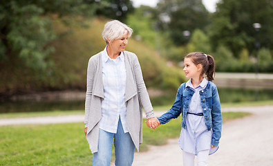 Image showing grandmother and granddaughter walking at park