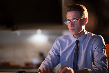 Image showing man working on computer in dark office