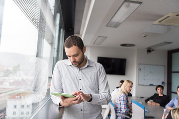 Image showing Businessman Using Tablet In Office Building by window