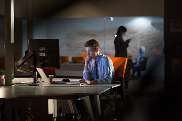 Image showing man working on computer in dark office