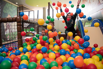 Image showing Young mom with her kids in a children\'s playroom