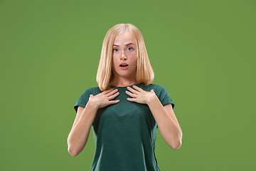 Image showing Beautiful woman looking suprised isolated on green