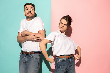 Image showing The young emotional angry woman on pink studio background