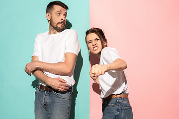 Image showing The young emotional angry woman on pink studio background