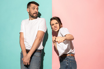 Image showing The young emotional angry woman on pink studio background