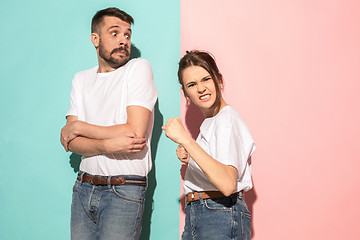 Image showing The young emotional angry woman on pink studio background