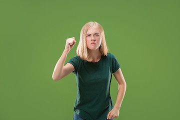 Image showing Portrait of an angry woman looking at camera isolated on a green background