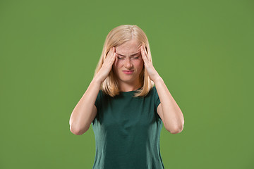 Image showing Woman having headache. Isolated over green background.