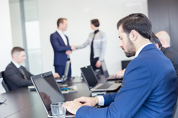 Image showing Business people shaking hands in moder corporate office.