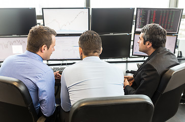 Image showing Business team brainstorming while checking data at computer screens.