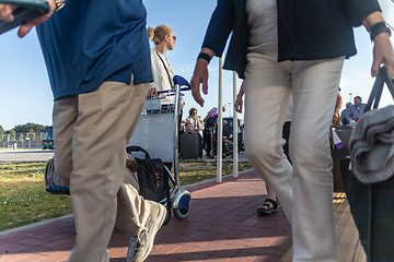 Image showing Young woman transporting luggage from arrival parking to international airport departure termainal by luggage trolley.