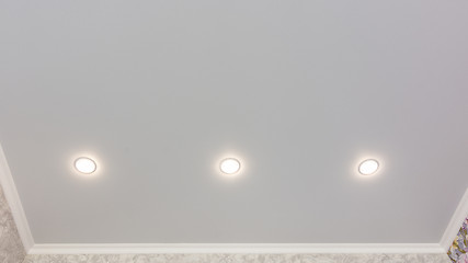 Image showing Fragment of the stretch ceiling with three spotlights in a row