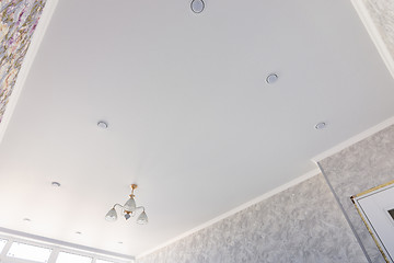 Image showing Stretch ceiling in a room with a chandelier and spotlights, with natural light