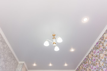 Image showing Stretch ceiling in the room with a chandelier and spotlights