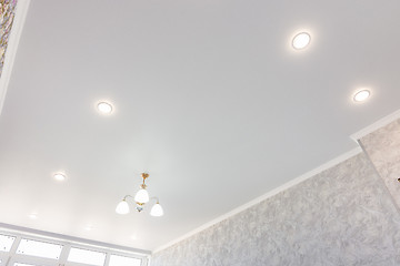 Image showing Stretch ceiling in the room with a chandelier and spotlights