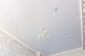 Image showing Stretch ceiling in a room with a chandelier and spotlights, with natural light