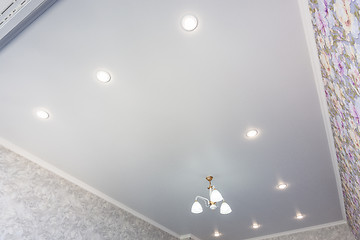 Image showing An outline of a stretch ceiling in a room with a chandelier and spotlights