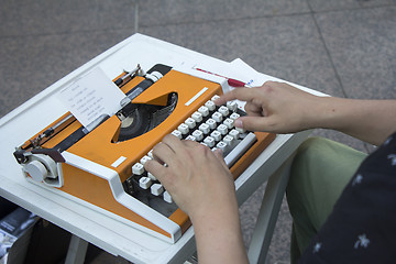 Image showing Young man working on old vintage manual typewriter