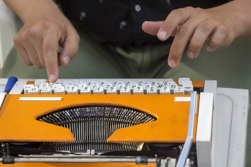 Image showing Young man working on old vintage manual typewriter