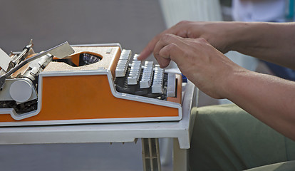 Image showing Young man working on old vintage manual typewriter