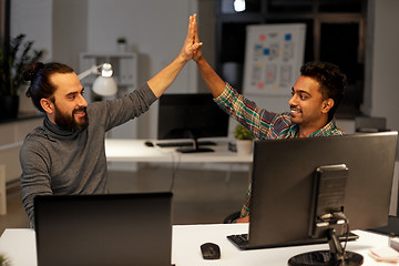 Image showing creative team making high five at night office