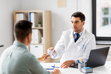 Image showing doctor giving medicine to male patient at hospital