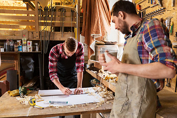 Image showing carpenters with ruler and blueprint at workshop