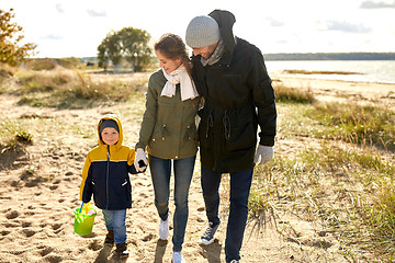 Image showing happy family walking along autumn beach