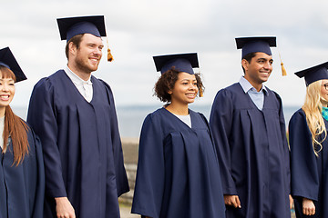 Image showing happy students or bachelors in mortar boards