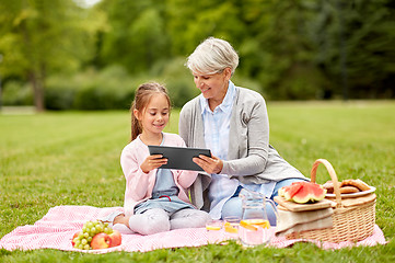 Image showing grandmother and granddaughter with tablet at park