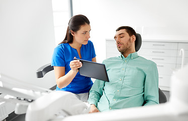 Image showing dentist and patient with tablet pc at clinic