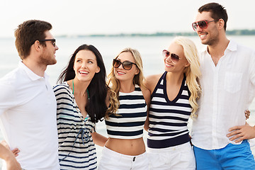 Image showing group of happy friends in striped clothes on beach