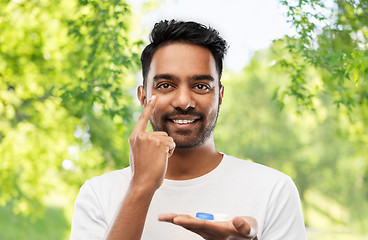 Image showing young indian man applying contact lenses