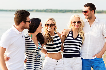 Image showing group of happy friends in striped clothes on beach