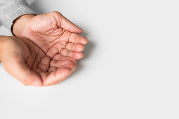 Image showing cupped senior man hands on table