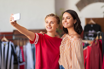 Image showing female friends taking selfie at clothing store