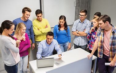 Image showing students and teacher with papers and laptop