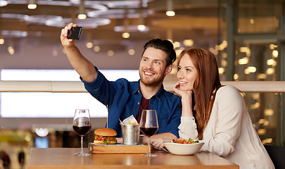 Image showing couple taking selfie by smartphone at restaurant