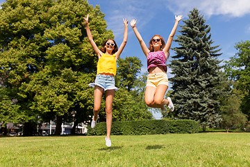 Image showing happy teenage girls jumping at summer park