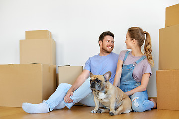 Image showing happy couple with boxes and dog moving to new home